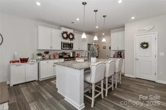 a kitchen with kitchen island wooden floor cabinets and a dining table