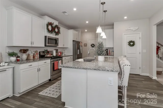a kitchen with kitchen island granite countertop a sink a center island and cabinets