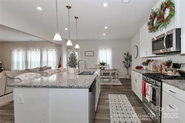 a kitchen with stainless steel appliances granite countertop a stove a sink and a refrigerator