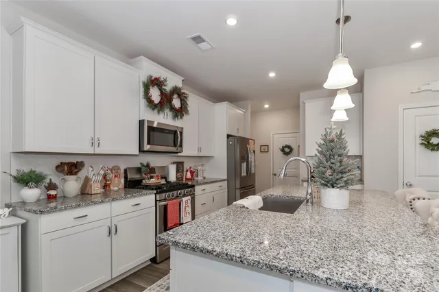 a kitchen with a sink a refrigerator and chairs