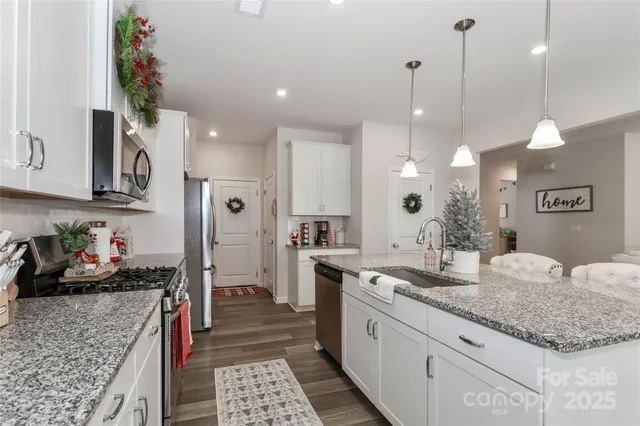 a kitchen with granite countertop a sink a stove and cabinets
