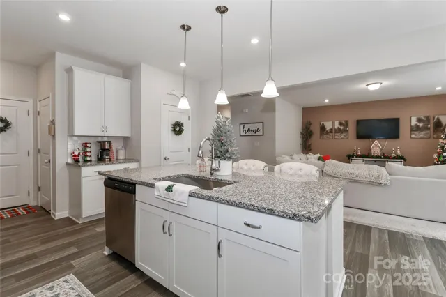 a large white kitchen with a sink and cabinets
