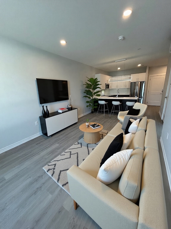148 Old Post Road, Unit 216 Sharon, MA 02067 - Photo 2 of 20 a living room with furniture and a flat screen tv