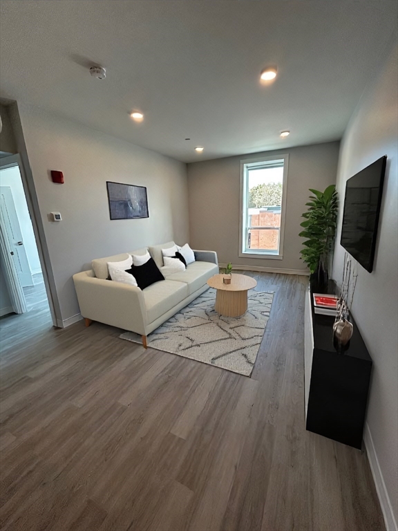 148 Old Post Road, Unit 216 Sharon, MA 02067 - Photo 4 of 20 a living room with furniture and a flat screen tv