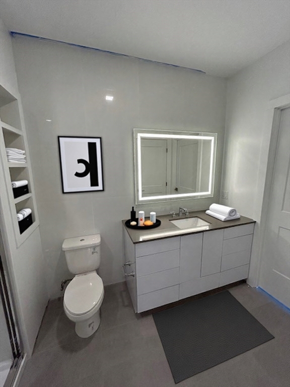 148 Old Post Road, Unit 216 Sharon, MA 02067 - Photo 7 of 20 a bathroom with a toilet a sink and mirror