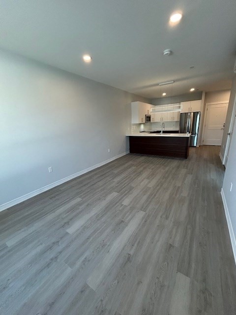 148 Old Post Road, Unit 216 Sharon, MA 02067 - Photo 7 of 22 a view of a big room with wooden floor and kitchen view