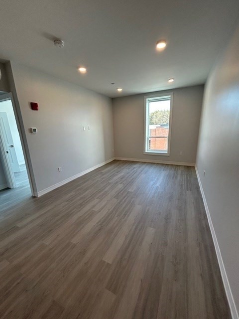 148 Old Post Road, Unit 216 Sharon, MA 02067 - Photo 8 of 22 an empty room with wooden floor and windows