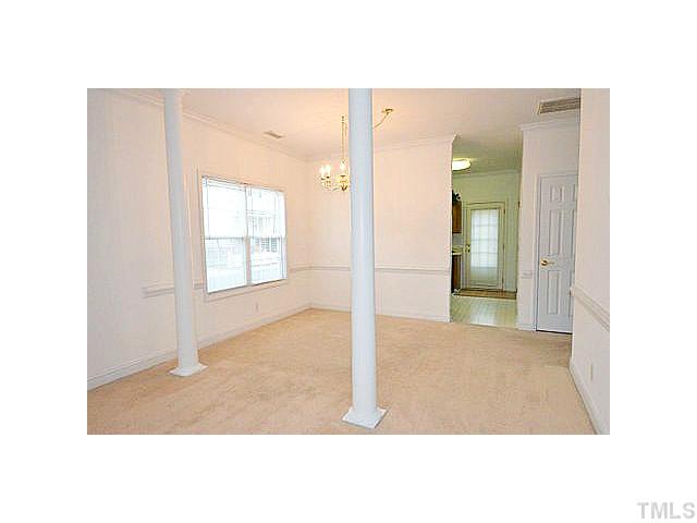 Formal dining room with crown and chair rail moldings and two columns.