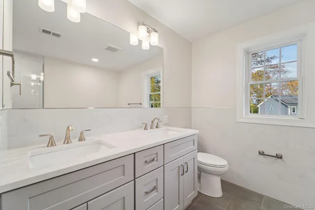 a bathroom with a toilet sink and mirror