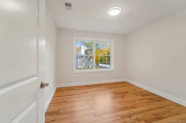 wooden floor in an empty room with a window