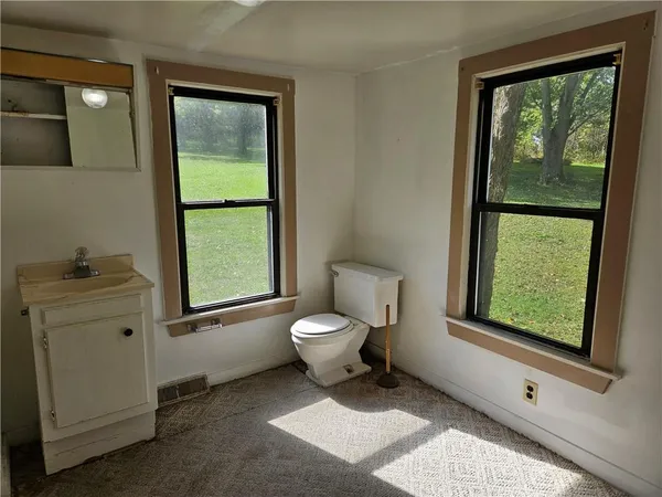 a bathroom with a toilet sink and window