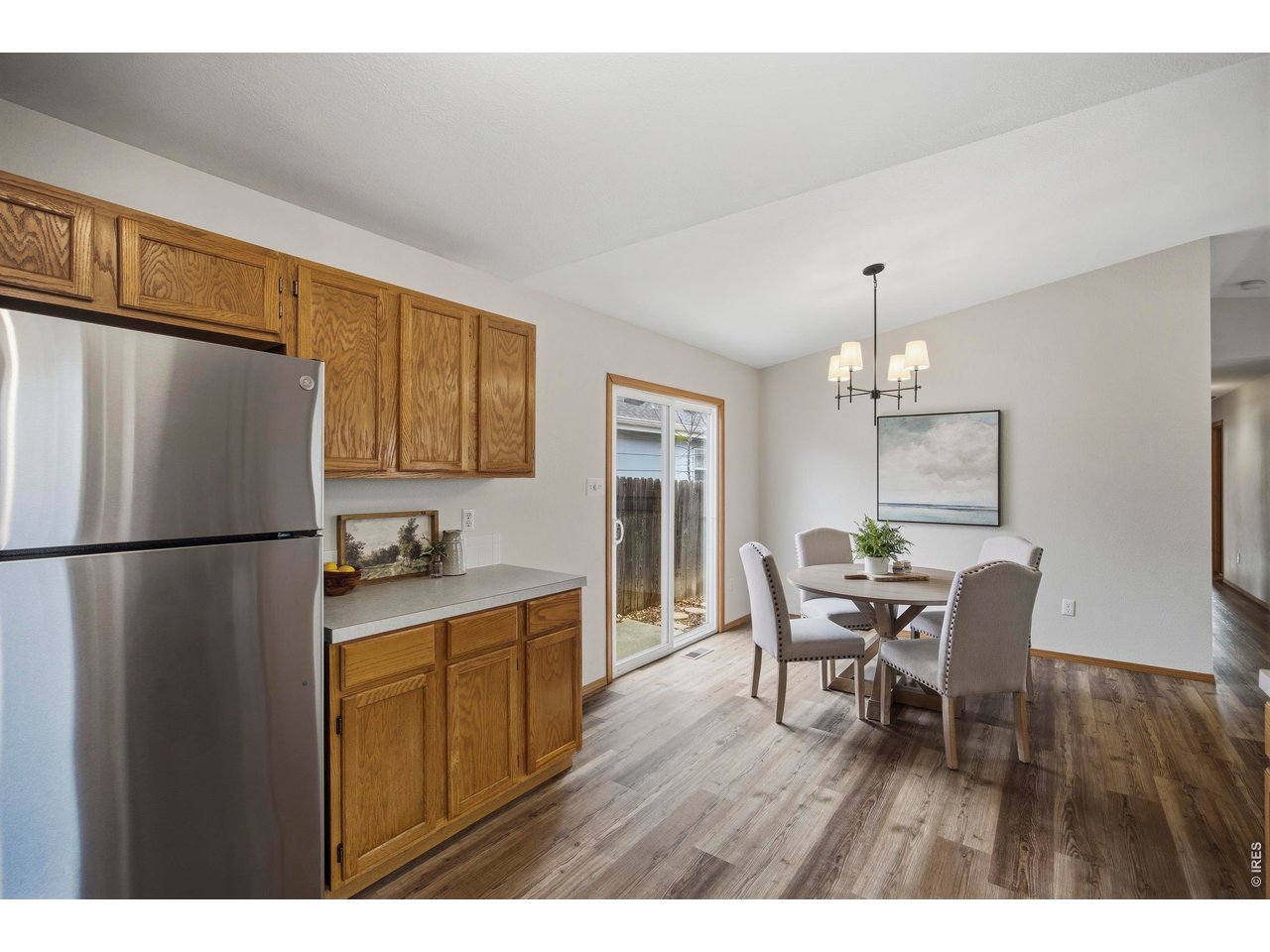 1225 Alameda Street Fort Collins, CO 80521 - Photo 11 of 32 a kitchen with stainless steel appliances a refrigerator a stove a dining table and chairs with wooden floor