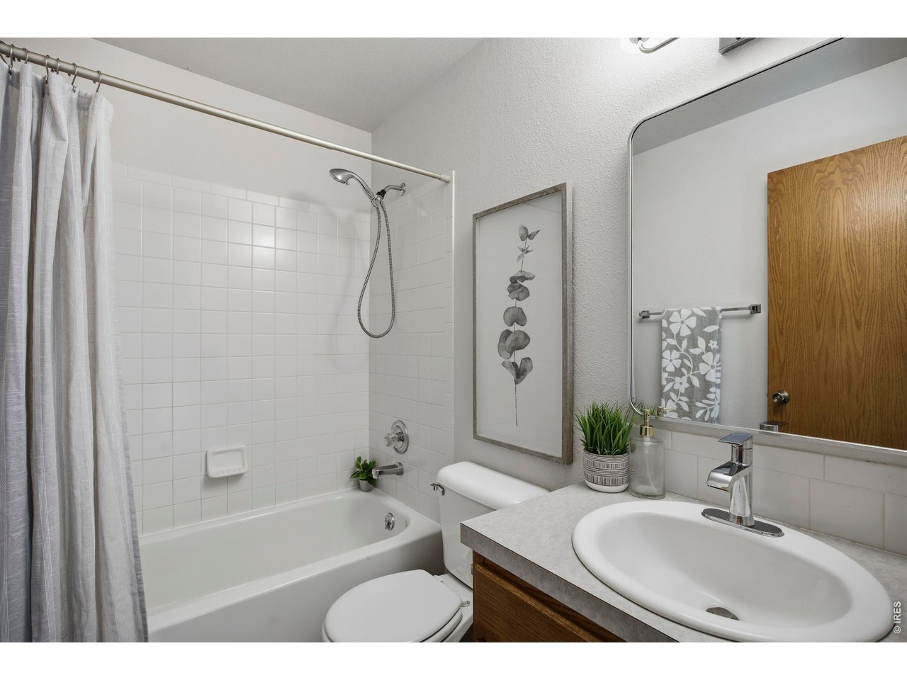 1225 Alameda Street Fort Collins, CO 80521 - Photo 14 of 32 a bathroom with a granite countertop sink a mirror a bathtub and shower