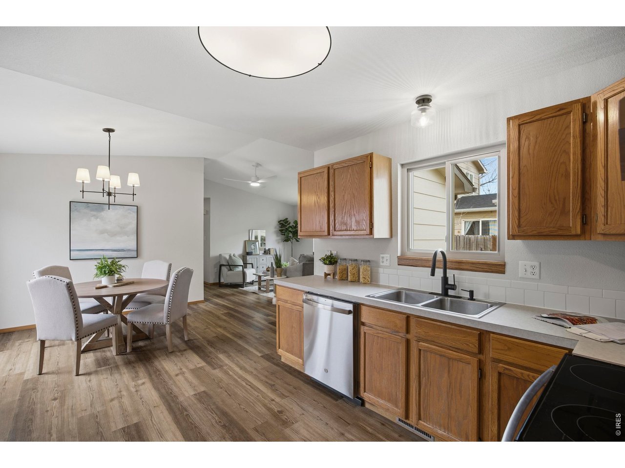 1225 Alameda Street Fort Collins, CO 80521 - Photo 10 of 32 a kitchen with a sink dishwasher a dining table and chairs with wooden floor