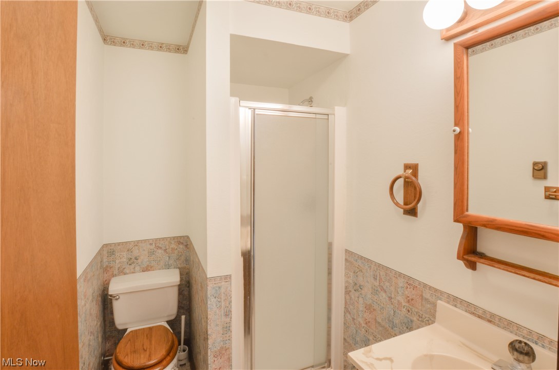 3120 West Elmore Road Port Clinton, OH 43452 - Photo 19 of 27 Bathroom with washbasin, mirror, and a shower with door