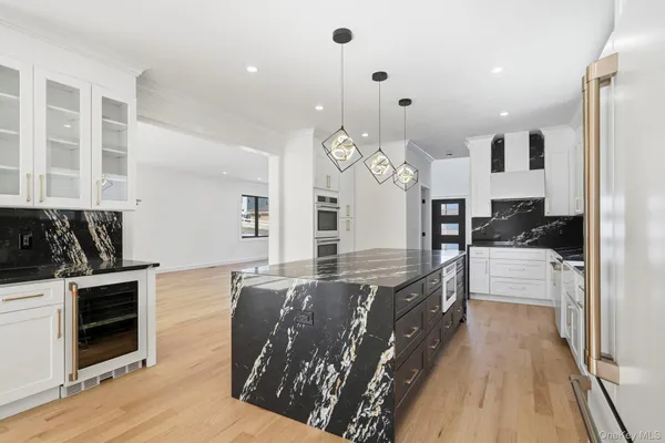 a large kitchen with granite countertop a stove top oven a sink a counter space and cabinets