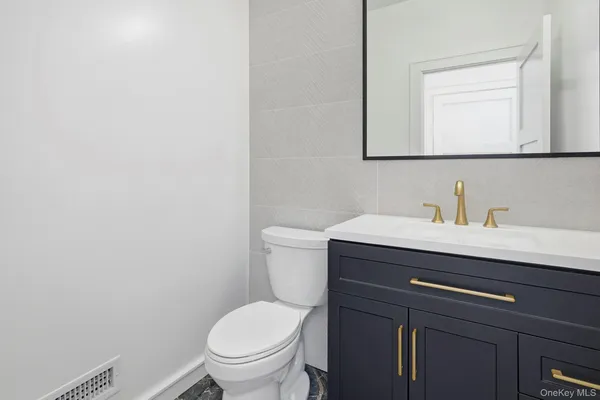 a bathroom with a sink a toilet and mirror