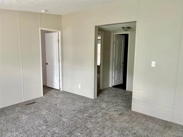 an empty room with closet and a bathroom