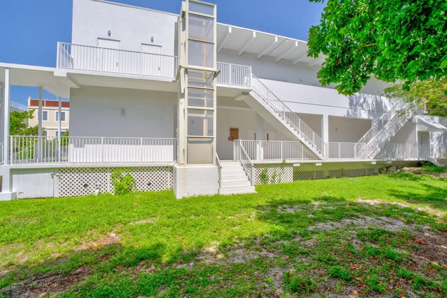 a view of an house with backyard and a tree