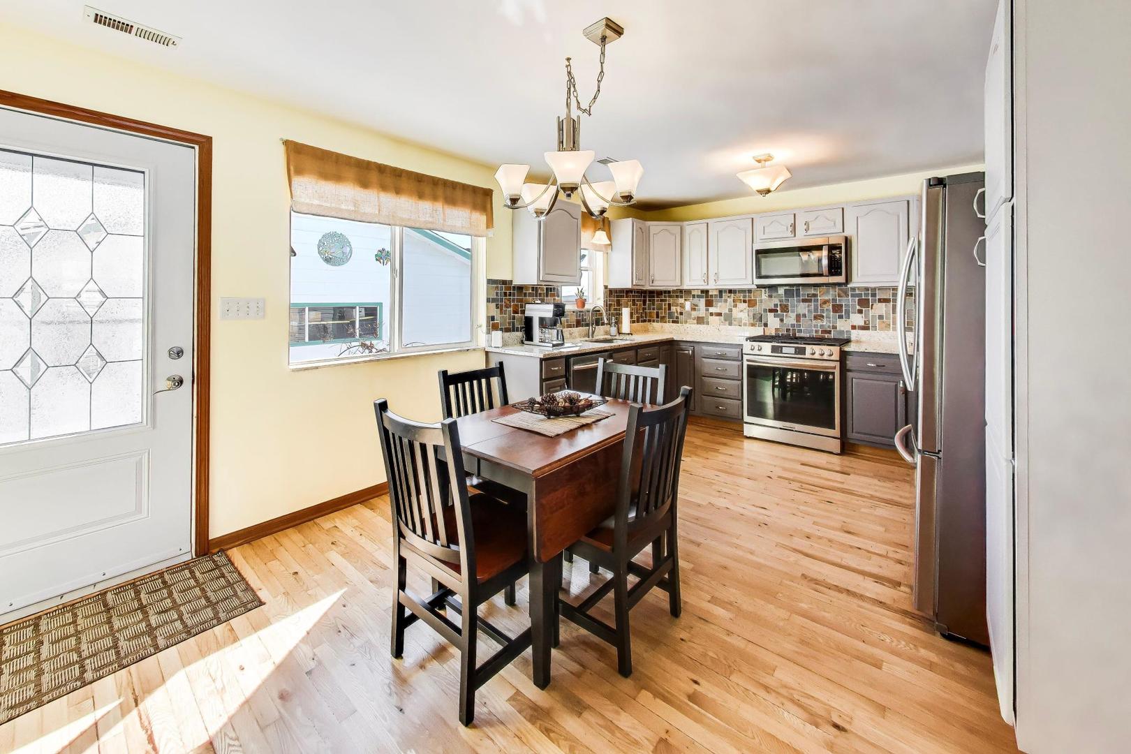 37464 North Terrace Lane Spring Grove, IL 60081 - Photo 5 of 40 a view of a dining room with furniture a chandelier and wooden floor