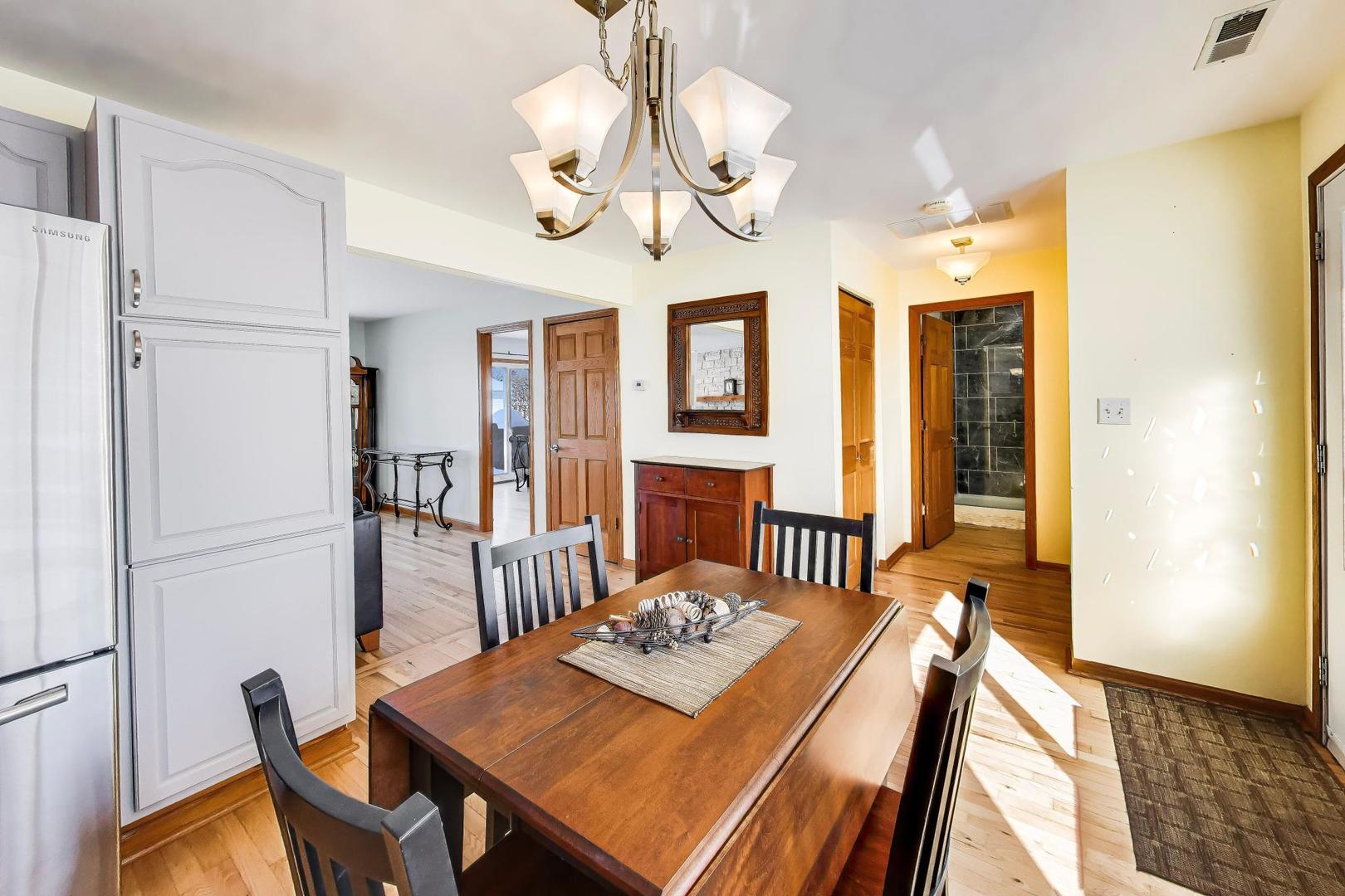 37464 North Terrace Lane Spring Grove, IL 60081 - Photo 7 of 40 a view of a dining room with furniture a chandelier and wooden floor
