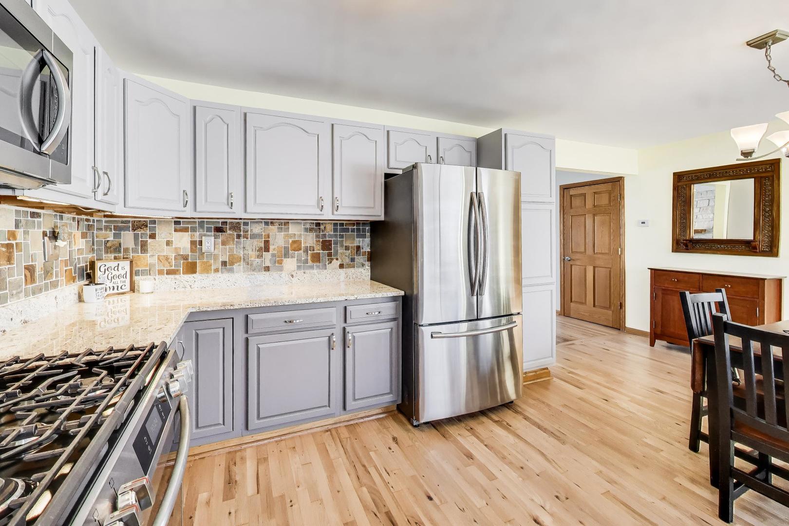 37464 North Terrace Lane Spring Grove, IL 60081 - Photo 10 of 40 a kitchen with stainless steel appliances a refrigerator stove and wooden floor