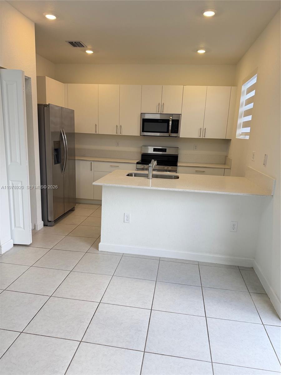 17953 Southwest 359th Street Homestead, FL 33034 - Photo 7 of 36 a kitchen with stainless steel appliances a refrigerator sink and microwave