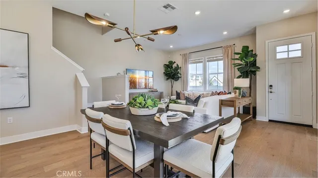 a dining room with furniture potted plants and wooden floor