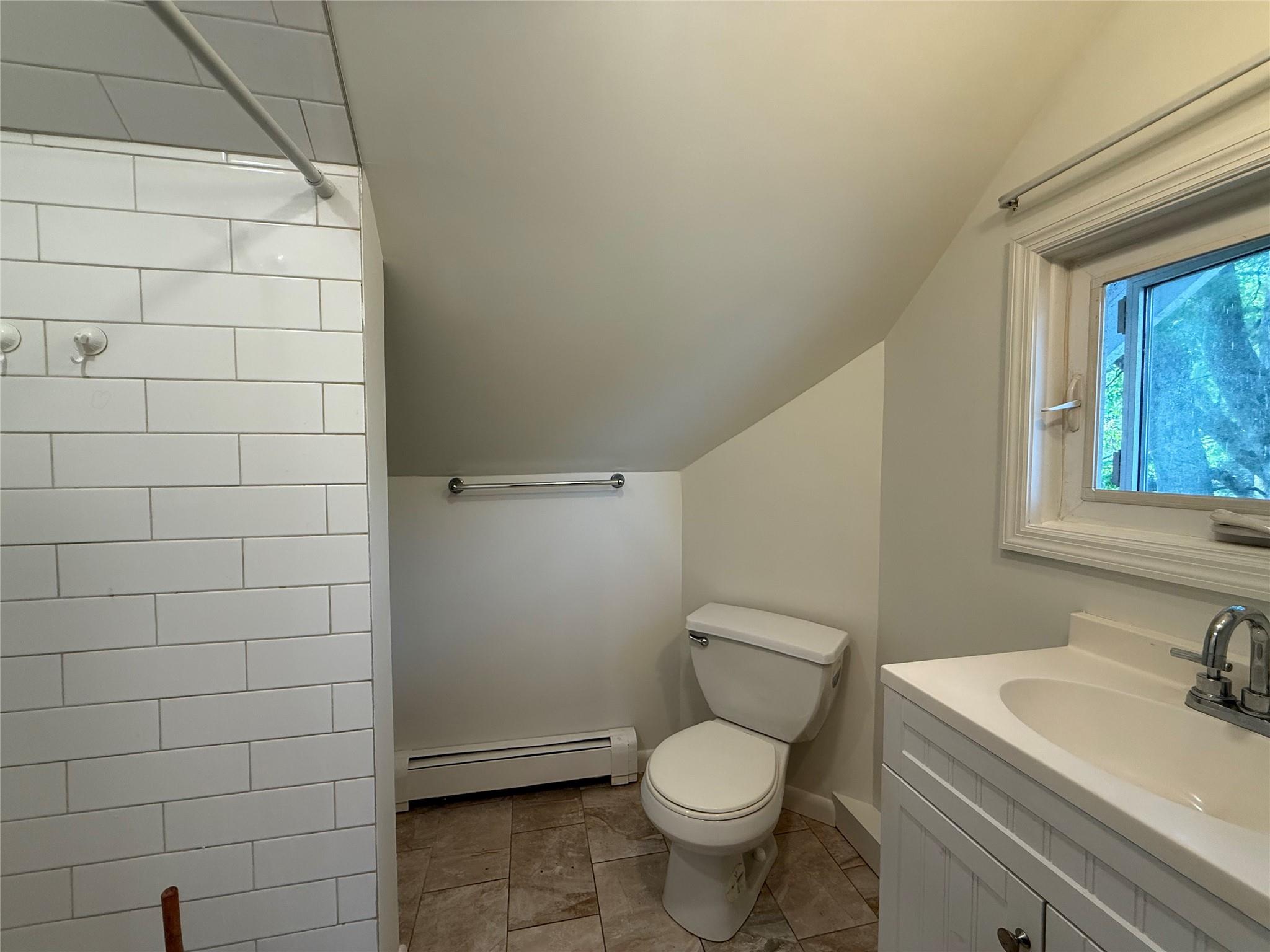 8 Harrison Street, Unit 3 Poughkeepsie, NY 12601 - Photo 6 of 6 Full bath featuring vaulted ceiling, a baseboard radiator, vanity, and tiled shower