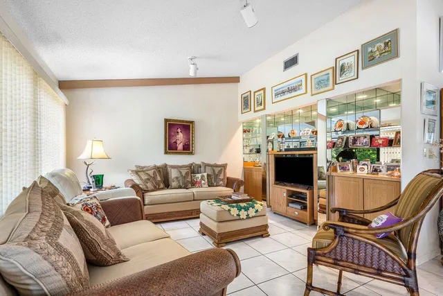 a living room with furniture a flat screen tv and a window