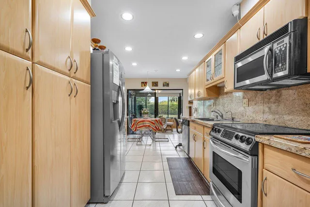 a kitchen with stainless steel appliances granite countertop a stove a sink and a refrigerator