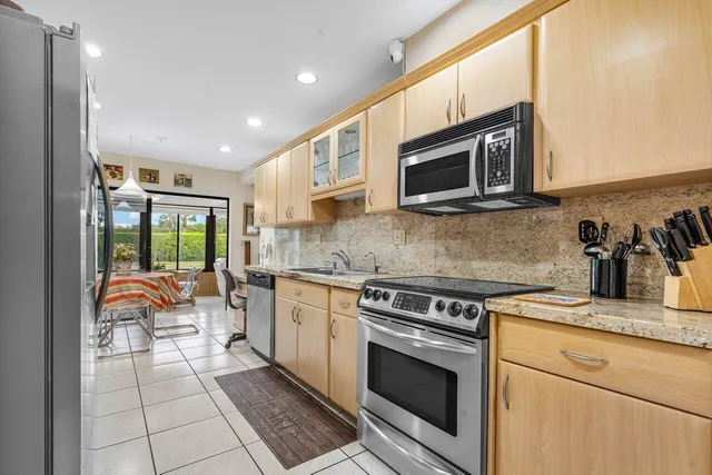 a kitchen with granite countertop a stove top oven microwave and cabinets