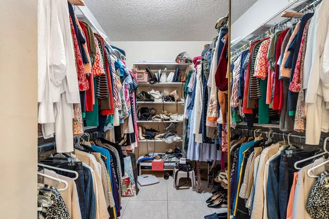 a view of walk in closet with clothes and shoes