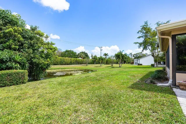a view of backyard with swimming pool and green space