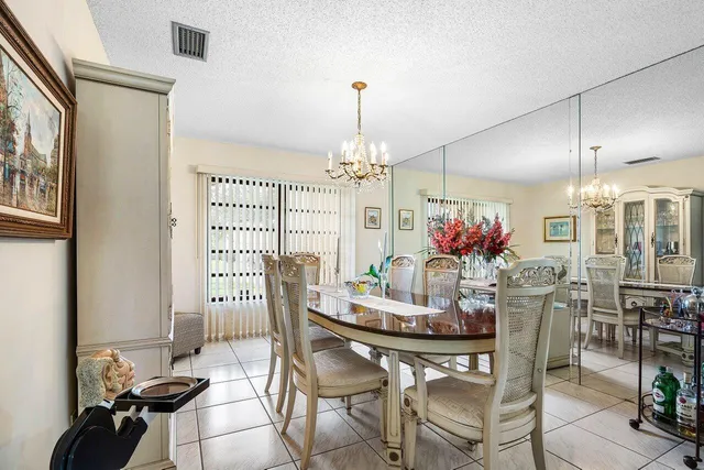 a dining room with furniture a chandelier and window
