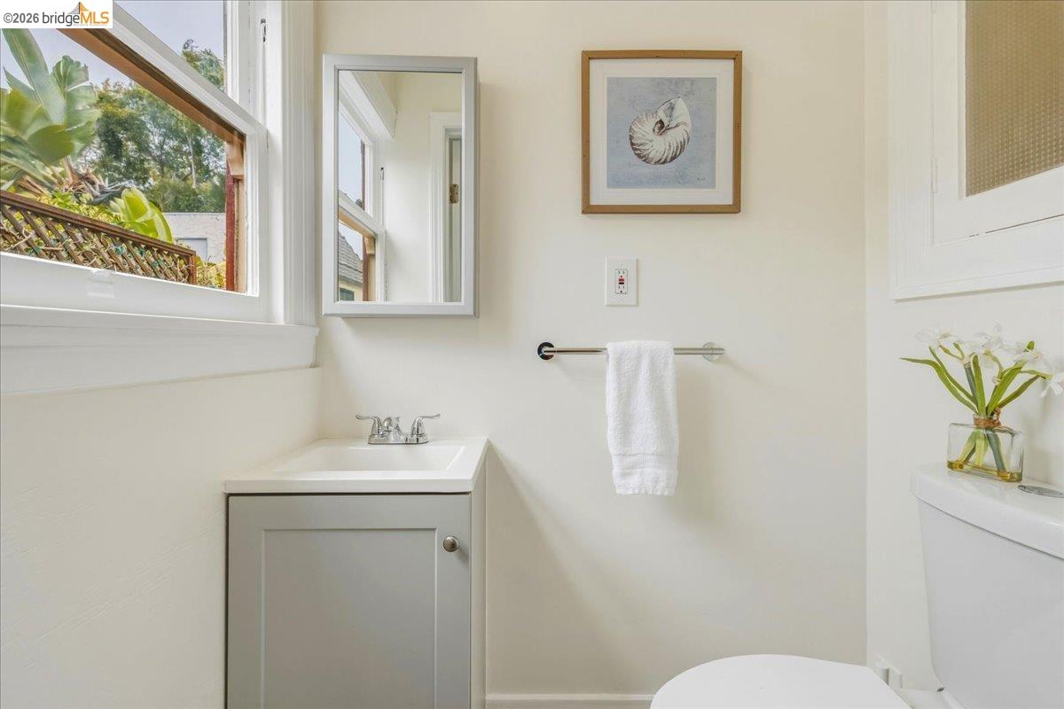 2403 Cedar Street Berkeley, CA 94708 - Photo 12 of 33 Bathroom with a single-pane window, white walls, and a gray vanity with an integrated sink