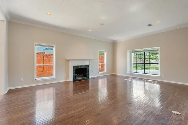 a view of empty room with wooden floor and fireplace