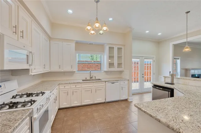 a large kitchen with stainless steel appliances granite countertop a sink dishwasher a stove a dining table and chairs with wooden floor