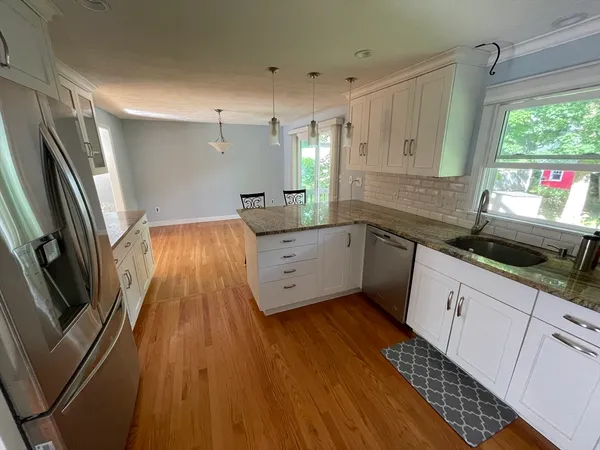 a kitchen with granite countertop a sink stainless steel appliances and cabinets