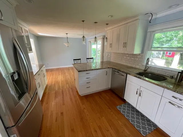 a kitchen with granite countertop a sink stainless steel appliances and cabinets
