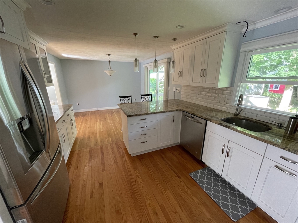 a kitchen with granite countertop a sink stainless steel appliances and cabinets