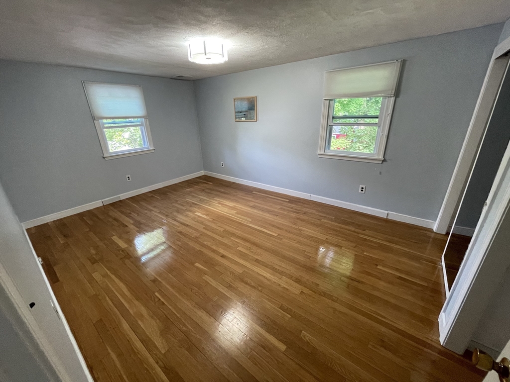 18 Charles Street Lexington, MA 02421 - Photo 16 of 30 wooden floor in an empty room with a window