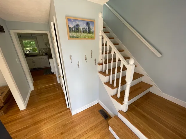 a view of a livingroom with wooden floor and stairs