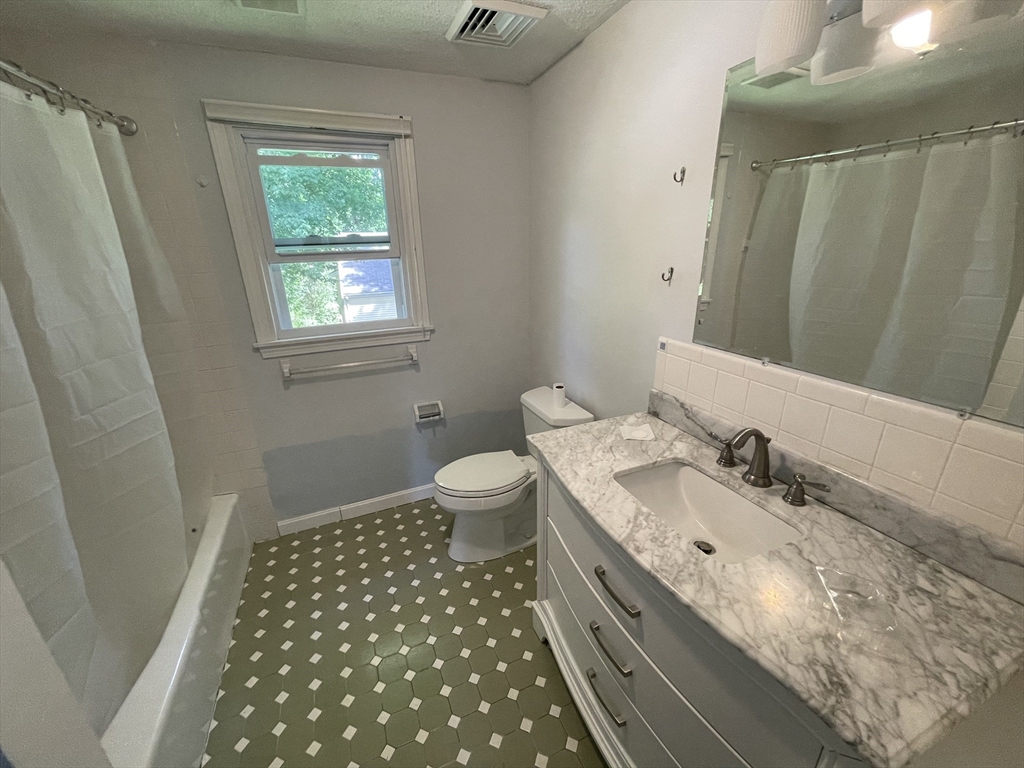 18 Charles Street Lexington, MA 02421 - Photo 26 of 30 a bathroom with a double vanity sink toilet and a mirror