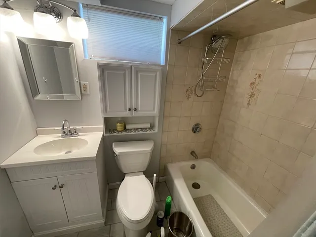 a bathroom with a toilet sink shower and mirror