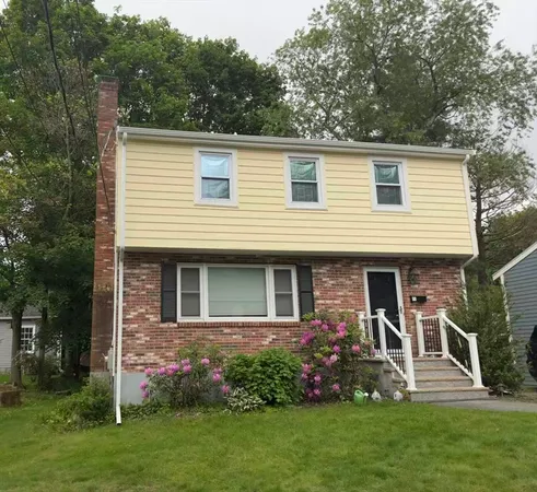 a front view of house with a garden