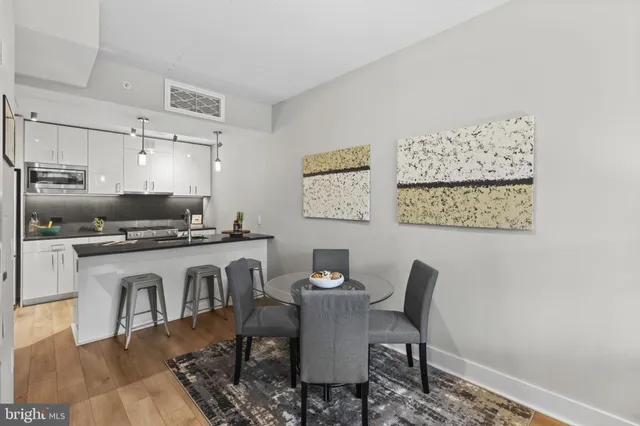a dining room with a table chairs and a kitchen view