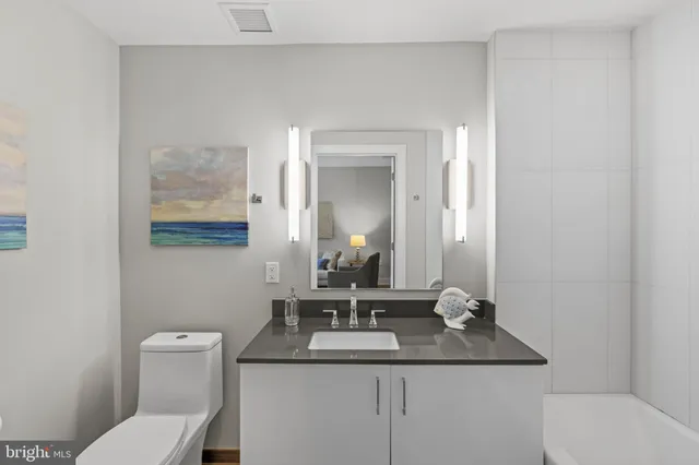 a bathroom with a toilet a sink and mirror