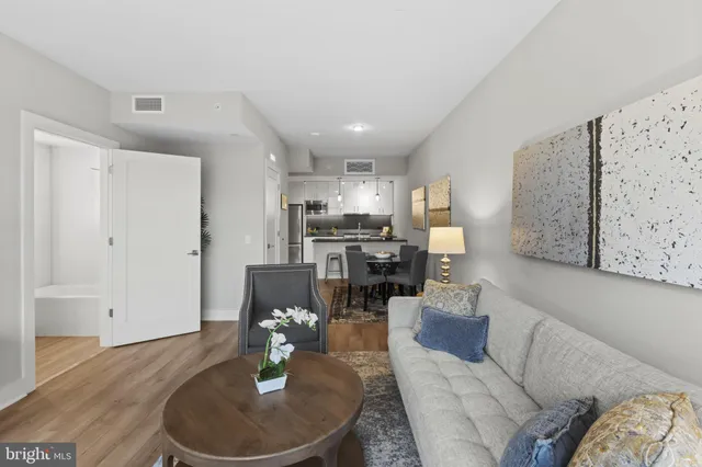a living room with furniture and kitchen view