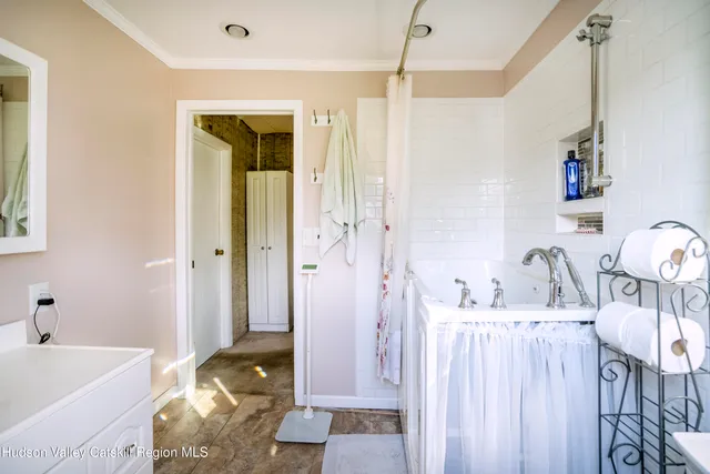 a bathroom with a tub sink and mirror